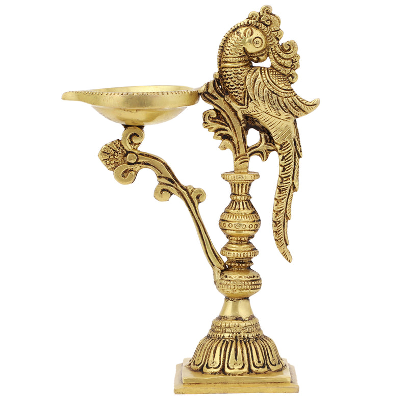 Brass peacock parrot Diya - exquisitely crafted brass oil lamp in the shape of a peacock with parrot motifs, golden finish, decorative home accent, fusion of elegance and vibrancy, traditional Indian Diya, emits a captivating and auspicious glow, perfect for festive occasions and religious ceremonies, enhances spiritual ambiance and decor with a touch of artistic brilliance.