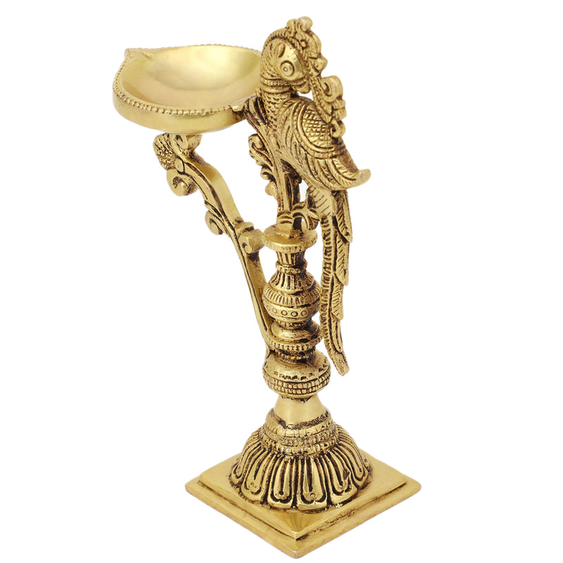 Brass peacock parrot Diya - exquisitely crafted brass oil lamp in the shape of a peacock with parrot motifs, golden finish, decorative home accent, fusion of elegance and vibrancy, traditional Indian Diya, emits a captivating and auspicious glow, perfect for festive occasions and religious ceremonies, enhances spiritual ambiance and decor with a touch of artistic brilliance.