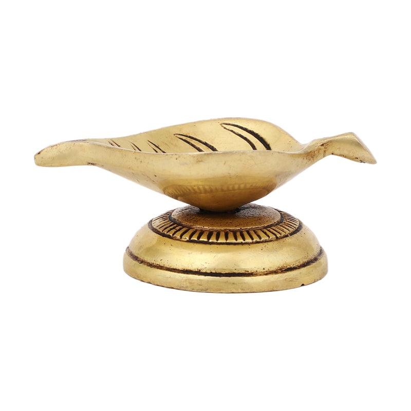 Brass Leaf Diya - elegantly crafted brass oil lamp in the shape of a leaf, golden finish, decorative home accent, inspired by nature's beauty, traditional Indian Diya, emits a soft and serene glow, ideal for religious ceremonies and festive occasions, enhances spiritual ambiance and decor with a touch of natural charm.