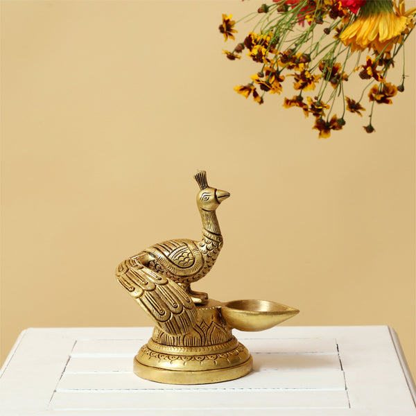 Brass peacock parrot Diya - exquisitely crafted brass oil lamp in the shape of a peacock with parrot motifs, golden finish, decorative home accent, fusion of elegance and vibrancy, traditional Indian Diya, emits a captivating and auspicious glow, perfect for festive occasions and religious ceremonies, enhances spiritual ambiance and decor with a touch of artistic brilliance.