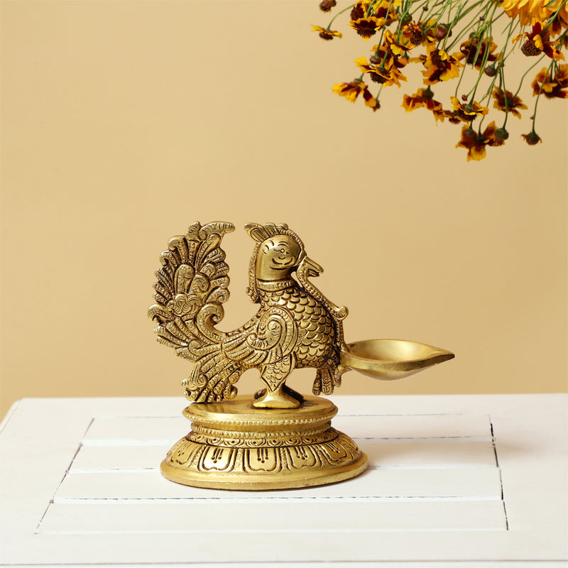 Brass peacock parrot Diya - exquisitely crafted brass oil lamp in the shape of a peacock with parrot motifs, golden finish, decorative home accent, fusion of elegance and vibrancy, traditional Indian Diya, emits a captivating and auspicious glow, perfect for festive occasions and religious ceremonies, enhances spiritual ambiance and decor with a touch of artistic brilliance.