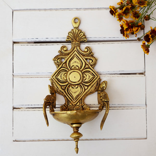 Brass Wall Diya - intricately designed brass oil lamp for wall mounting, golden finish, decorative home accent, traditional Indian Diya, emits a warm and inviting glow, ideal for enhancing wall decor and creating an ambiance of serenity, perfect for religious ceremonies and festive occasions, adds a touch of traditional charm to interior spaces.