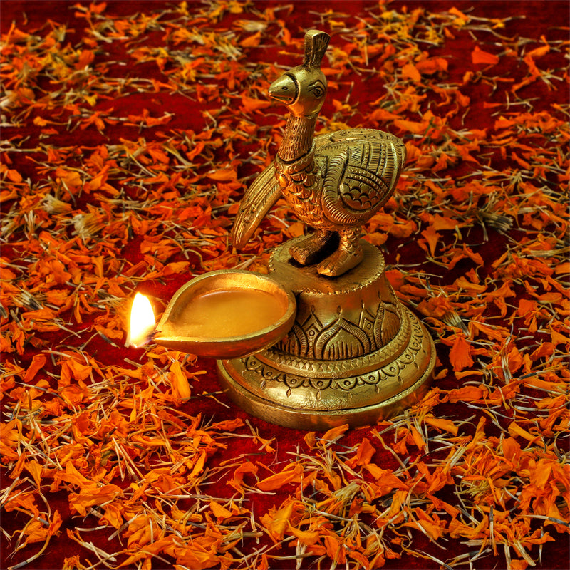 Brass peacock parrot Diya - exquisitely crafted brass oil lamp in the shape of a peacock with parrot motifs, golden finish, decorative home accent, fusion of elegance and vibrancy, traditional Indian Diya, emits a captivating and auspicious glow, perfect for festive occasions and religious ceremonies, enhances spiritual ambiance and decor with a touch of artistic brilliance.