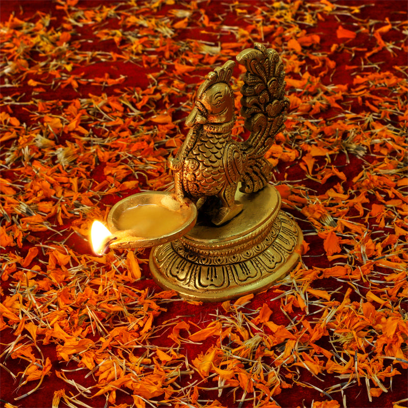 Brass peacock parrot Diya - exquisitely crafted brass oil lamp in the shape of a peacock with parrot motifs, golden finish, decorative home accent, fusion of elegance and vibrancy, traditional Indian Diya, emits a captivating and auspicious glow, perfect for festive occasions and religious ceremonies, enhances spiritual ambiance and decor with a touch of artistic brilliance.