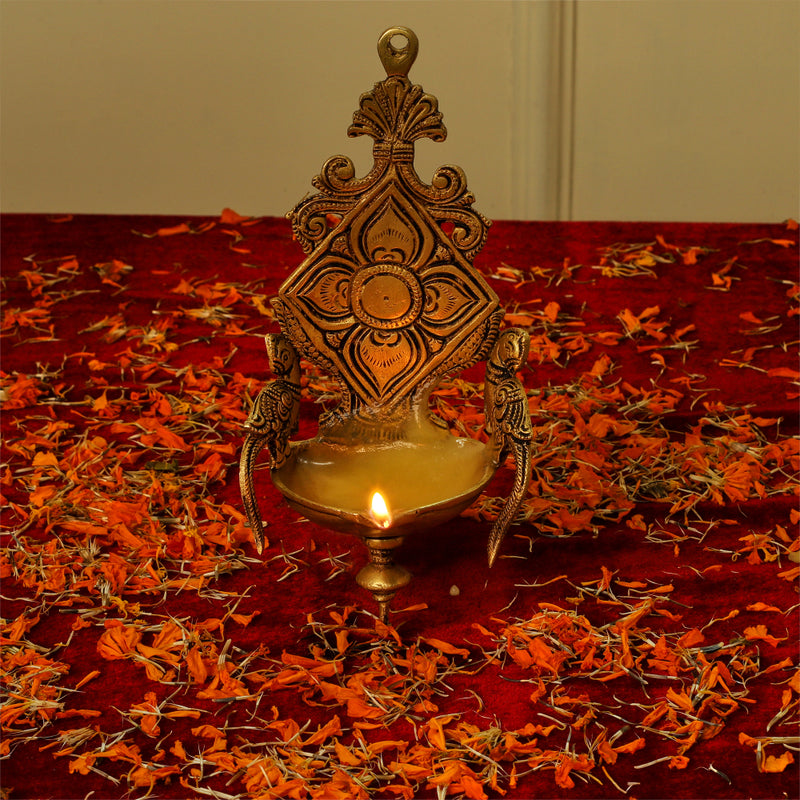 Brass Wall Diya - intricately designed brass oil lamp for wall mounting, golden finish, decorative home accent, traditional Indian Diya, emits a warm and inviting glow, ideal for enhancing wall decor and creating an ambiance of serenity, perfect for religious ceremonies and festive occasions, adds a touch of traditional charm to interior spaces.