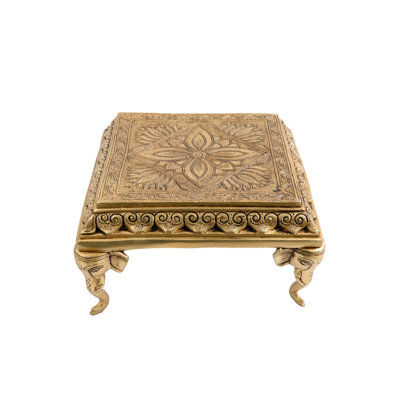 Brass Chowki - intricately carved brass platform, golden finish, perfect for placing deities or sacred objects during religious ceremonies and rituals, enhances the sanctity and beauty of the worship space, symbolizes stability and divine presence, adds a touch of elegance to your home puja setup, a valuable and ornamental addition to your collection of brass religious artifacts and decor.