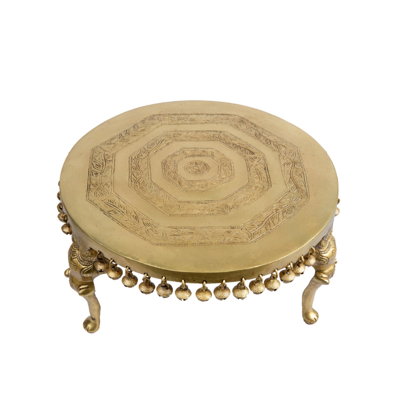 Brass Chowki - intricately carved brass platform, golden finish, perfect for placing deities or sacred objects during religious ceremonies and rituals, enhances the sanctity and beauty of the worship space, symbolizes stability and divine presence, adds a touch of elegance to your home puja setup, a valuable and ornamental addition to your collection of brass religious artifacts and decor.