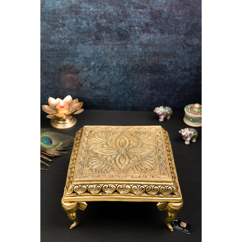 Brass Chowki - intricately carved brass platform, golden finish, perfect for placing deities or sacred objects during religious ceremonies and rituals, enhances the sanctity and beauty of the worship space, symbolizes stability and divine presence, adds a touch of elegance to your home puja setup, a valuable and ornamental addition to your collection of brass religious artifacts and decor.