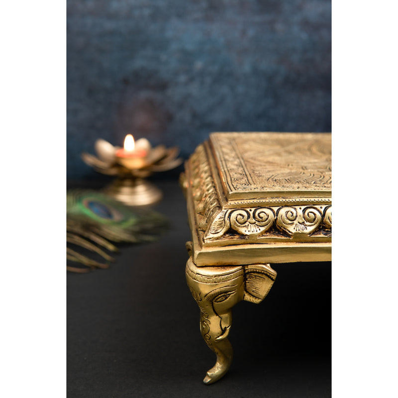 Brass Chowki - intricately carved brass platform, golden finish, perfect for placing deities or sacred objects during religious ceremonies and rituals, enhances the sanctity and beauty of the worship space, symbolizes stability and divine presence, adds a touch of elegance to your home puja setup, a valuable and ornamental addition to your collection of brass religious artifacts and decor.