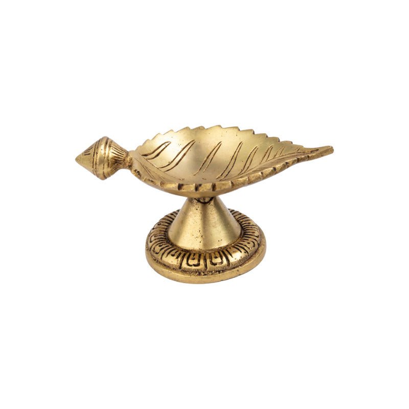 Brass Leaf Diya - elegantly crafted brass oil lamp in the shape of a leaf, golden finish, decorative home accent, inspired by nature's beauty, traditional Indian Diya, emits a soft and serene glow, ideal for religious ceremonies and festive occasions, enhances spiritual ambiance and decor with a touch of natural charm.