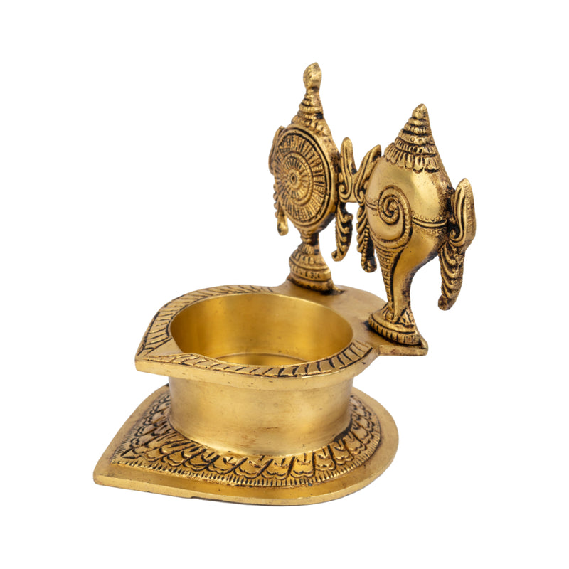 Brass Shank Chakra Diya - beautifully crafted brass oil lamp in the shape of a conch shell with chakra design, golden finish, decorative home accent, symbolizes purity and spiritual energy, traditional Indian Diya, emits a divine and serene glow, ideal for religious ceremonies and meditation, enhances spiritual ambiance and decor with a touch of sacredness.