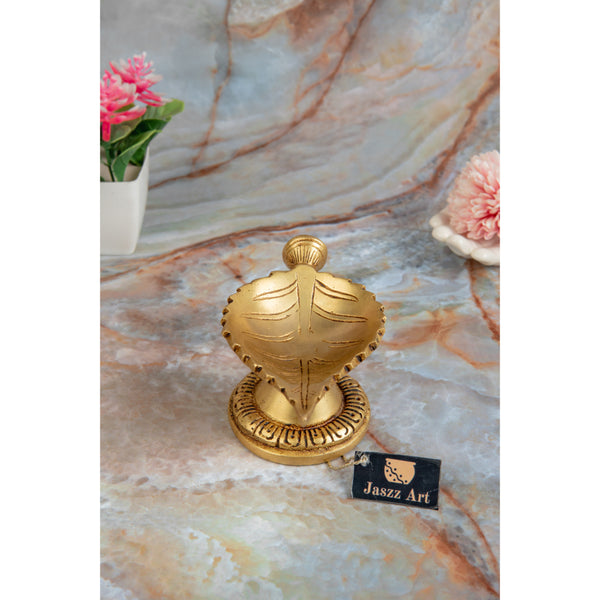 Brass Leaf Diya - elegantly crafted brass oil lamp in the shape of a leaf, golden finish, decorative home accent, inspired by nature's beauty, traditional Indian Diya, emits a soft and serene glow, ideal for religious ceremonies and festive occasions, enhances spiritual ambiance and decor with a touch of natural charm.