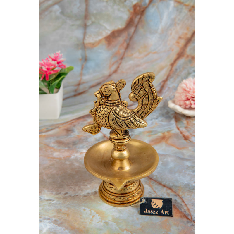 Brass peacock parrot Diya - exquisitely crafted brass oil lamp in the shape of a peacock with parrot motifs, golden finish, decorative home accent, fusion of elegance and vibrancy, traditional Indian Diya, emits a captivating and auspicious glow, perfect for festive occasions and religious ceremonies, enhances spiritual ambiance and decor with a touch of artistic brilliance.