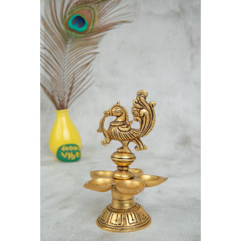 Brass peacock parrot Diya - exquisitely crafted brass oil lamp in the shape of a peacock with parrot motifs, golden finish, decorative home accent, fusion of elegance and vibrancy, traditional Indian Diya, emits a captivating and auspicious glow, perfect for festive occasions and religious ceremonies, enhances spiritual ambiance and decor with a touch of artistic brilliance.