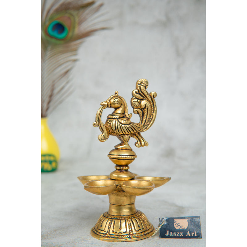 Brass peacock parrot Diya - exquisitely crafted brass oil lamp in the shape of a peacock with parrot motifs, golden finish, decorative home accent, fusion of elegance and vibrancy, traditional Indian Diya, emits a captivating and auspicious glow, perfect for festive occasions and religious ceremonies, enhances spiritual ambiance and decor with a touch of artistic brilliance.