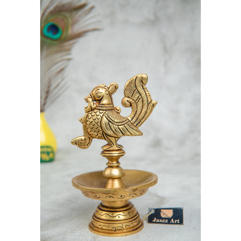 Brass peacock parrot Diya - exquisitely crafted brass oil lamp in the shape of a peacock with parrot motifs, golden finish, decorative home accent, fusion of elegance and vibrancy, traditional Indian Diya, emits a captivating and auspicious glow, perfect for festive occasions and religious ceremonies, enhances spiritual ambiance and decor with a touch of artistic brilliance.