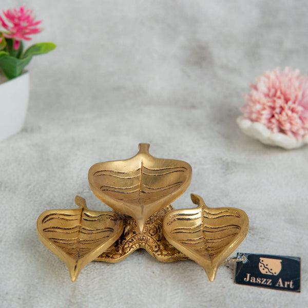 Brass Leaf Diya - elegantly crafted brass oil lamp in the shape of a leaf, golden finish, decorative home accent, inspired by nature's beauty, traditional Indian Diya, emits a soft and serene glow, ideal for religious ceremonies and festive occasions, enhances spiritual ambiance and decor with a touch of natural charm.