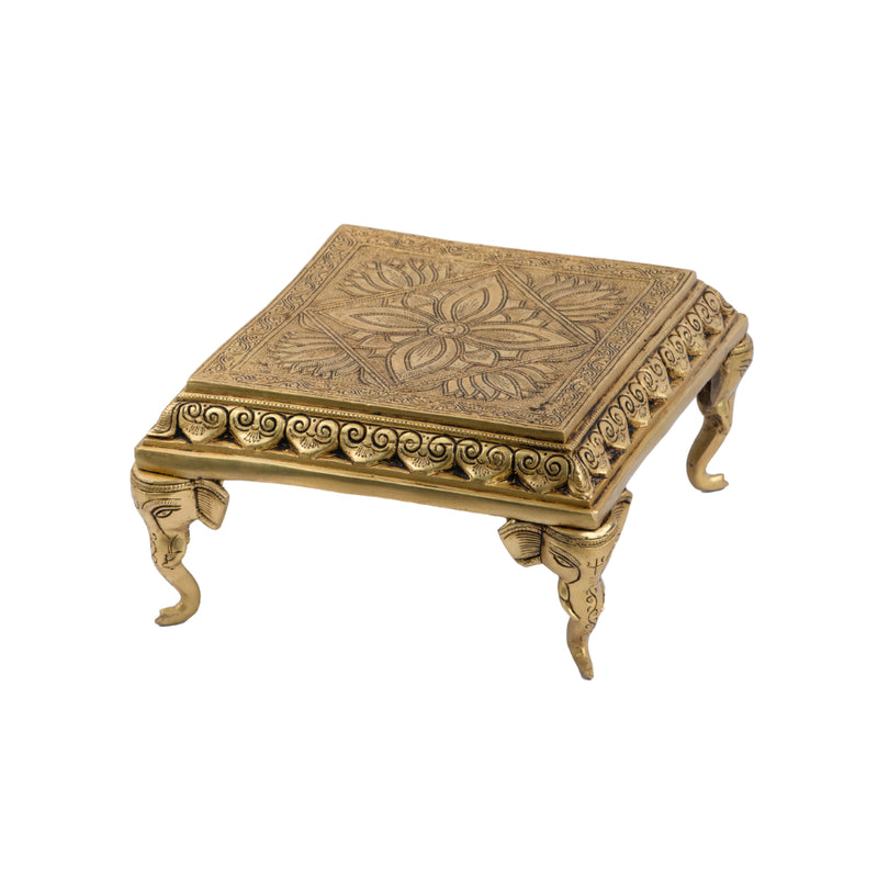 Brass Chowki - intricately carved brass platform, golden finish, perfect for placing deities or sacred objects during religious ceremonies and rituals, enhances the sanctity and beauty of the worship space, symbolizes stability and divine presence, adds a touch of elegance to your home puja setup, a valuable and ornamental addition to your collection of brass religious artifacts and decor.