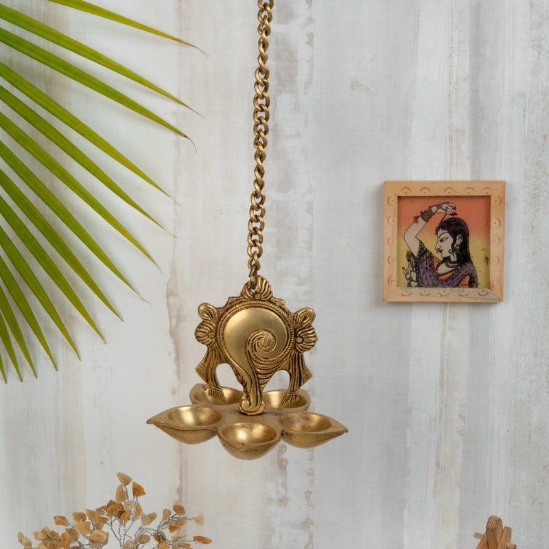 Brass Wall Diya - intricately designed brass oil lamp for wall mounting, golden finish, decorative home accent, traditional Indian Diya, emits a warm and inviting glow, ideal for enhancing wall decor and creating an ambiance of serenity, perfect for religious ceremonies and festive occasions, adds a touch of traditional charm to interior spaces.