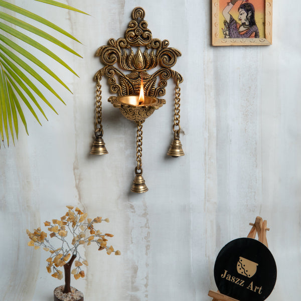 Brass Wall Diya - intricately designed brass oil lamp for wall mounting, golden finish, decorative home accent, traditional Indian Diya, emits a warm and inviting glow, ideal for enhancing wall decor and creating an ambiance of serenity, perfect for religious ceremonies and festive occasions, adds a touch of traditional charm to interior spaces.