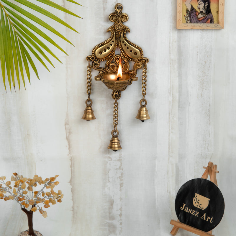 Brass Wall Diya - intricately designed brass oil lamp for wall mounting, golden finish, decorative home accent, traditional Indian Diya, emits a warm and inviting glow, ideal for enhancing wall decor and creating an ambiance of serenity, perfect for religious ceremonies and festive occasions, adds a touch of traditional charm to interior spaces.