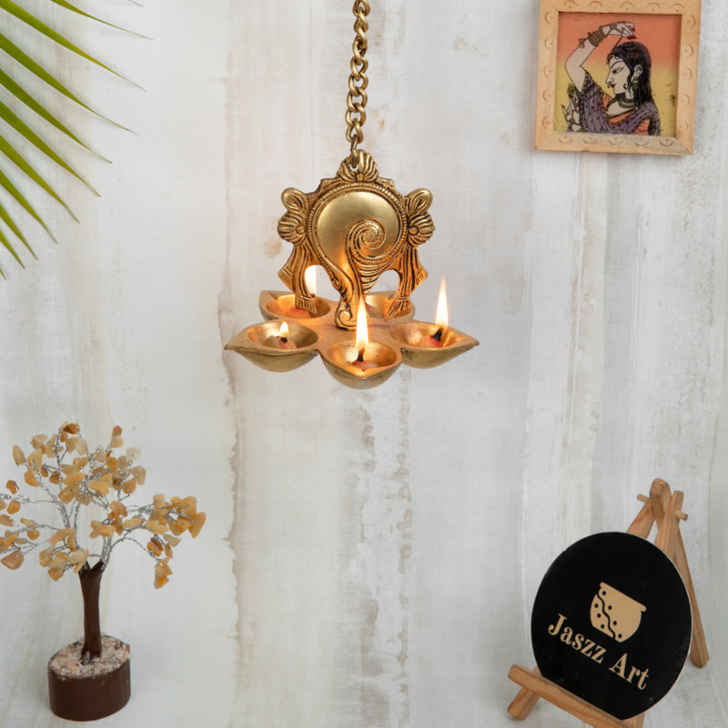 Brass Wall Diya - intricately designed brass oil lamp for wall mounting, golden finish, decorative home accent, traditional Indian Diya, emits a warm and inviting glow, ideal for enhancing wall decor and creating an ambiance of serenity, perfect for religious ceremonies and festive occasions, adds a touch of traditional charm to interior spaces.