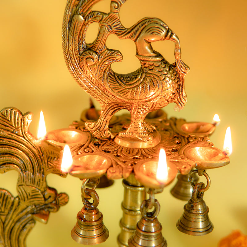 Brass peacock parrot Diya - exquisitely crafted brass oil lamp in the shape of a peacock with parrot motifs, golden finish, decorative home accent, fusion of elegance and vibrancy, traditional Indian Diya, emits a captivating and auspicious glow, perfect for festive occasions and religious ceremonies, enhances spiritual ambiance and decor with a touch of artistic brilliance.