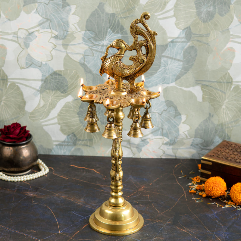 Brass peacock parrot Diya - exquisitely crafted brass oil lamp in the shape of a peacock with parrot motifs, golden finish, decorative home accent, fusion of elegance and vibrancy, traditional Indian Diya, emits a captivating and auspicious glow, perfect for festive occasions and religious ceremonies, enhances spiritual ambiance and decor with a touch of artistic brilliance.