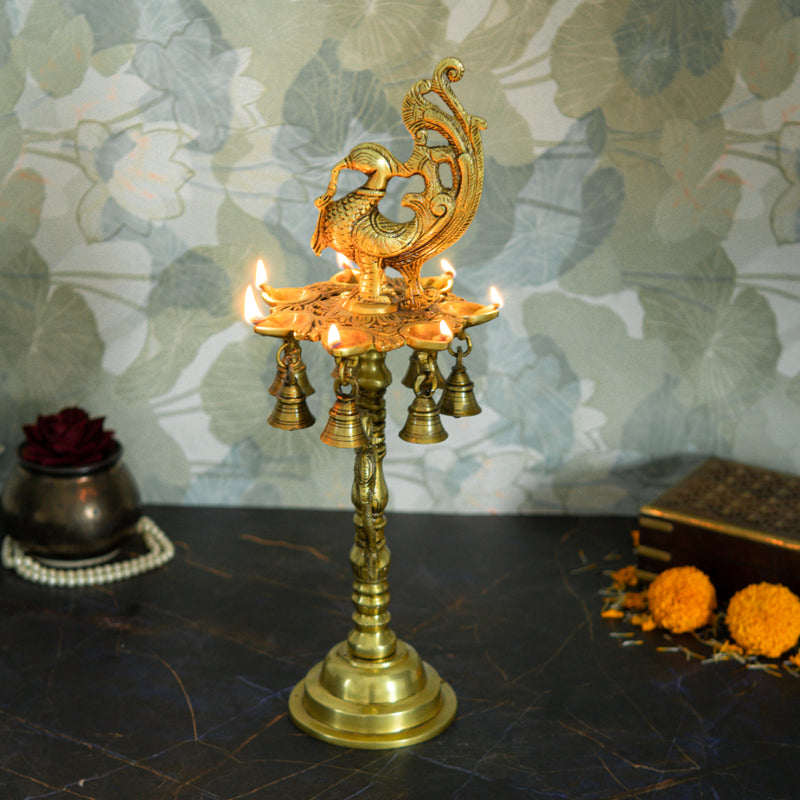 Brass peacock parrot Diya - exquisitely crafted brass oil lamp in the shape of a peacock with parrot motifs, golden finish, decorative home accent, fusion of elegance and vibrancy, traditional Indian Diya, emits a captivating and auspicious glow, perfect for festive occasions and religious ceremonies, enhances spiritual ambiance and decor with a touch of artistic brilliance.