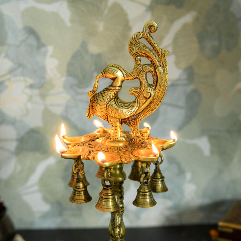 Brass peacock parrot Diya - exquisitely crafted brass oil lamp in the shape of a peacock with parrot motifs, golden finish, decorative home accent, fusion of elegance and vibrancy, traditional Indian Diya, emits a captivating and auspicious glow, perfect for festive occasions and religious ceremonies, enhances spiritual ambiance and decor with a touch of artistic brilliance.