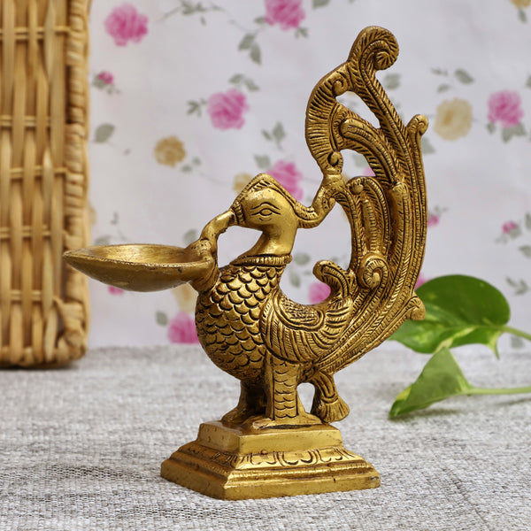 Brass peacock parrot Diya - exquisitely crafted brass oil lamp in the shape of a peacock with parrot motifs, golden finish, decorative home accent, fusion of elegance and vibrancy, traditional Indian Diya, emits a captivating and auspicious glow, perfect for festive occasions and religious ceremonies, enhances spiritual ambiance and decor with a touch of artistic brilliance.