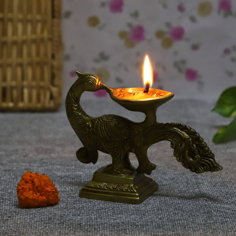 Brass peacock parrot Diya - exquisitely crafted brass oil lamp in the shape of a peacock with parrot motifs, golden finish, decorative home accent, fusion of elegance and vibrancy, traditional Indian Diya, emits a captivating and auspicious glow, perfect for festive occasions and religious ceremonies, enhances spiritual ambiance and decor with a touch of artistic brilliance.