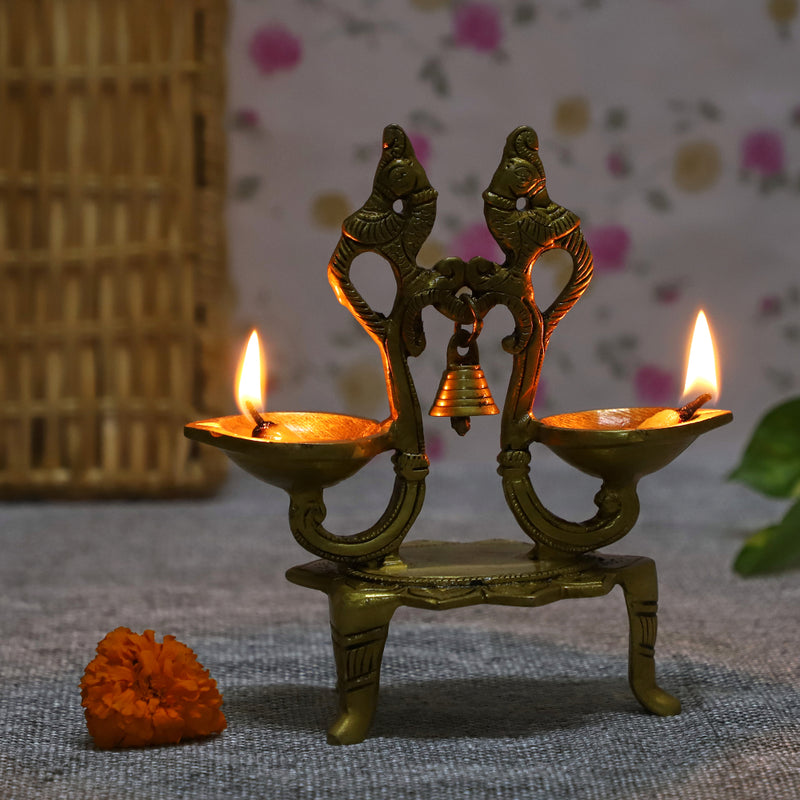 Brass peacock parrot Diya - exquisitely crafted brass oil lamp in the shape of a peacock with parrot motifs, golden finish, decorative home accent, fusion of elegance and vibrancy, traditional Indian Diya, emits a captivating and auspicious glow, perfect for festive occasions and religious ceremonies, enhances spiritual ambiance and decor with a touch of artistic brilliance.