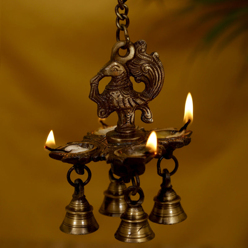 Brass peacock parrot Diya - exquisitely crafted brass oil lamp in the shape of a peacock with parrot motifs, golden finish, decorative home accent, fusion of elegance and vibrancy, traditional Indian Diya, emits a captivating and auspicious glow, perfect for festive occasions and religious ceremonies, enhances spiritual ambiance and decor with a touch of artistic brilliance.