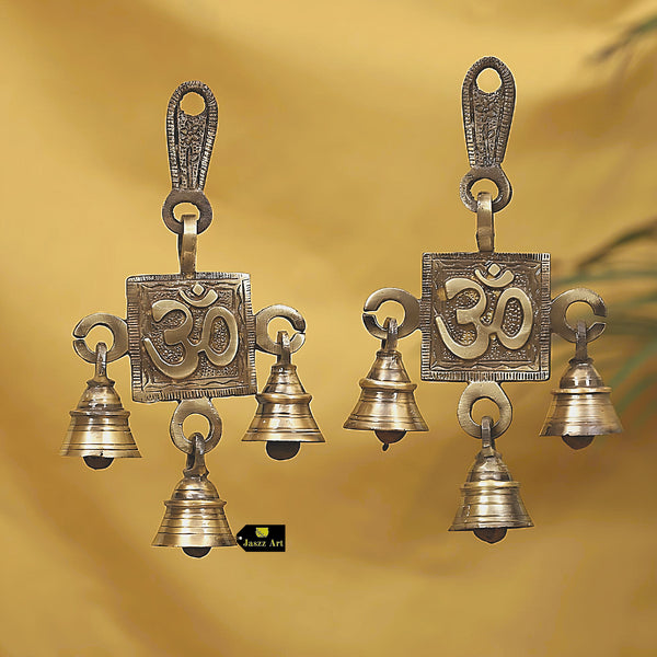 Brass OM Bells - intricately designed brass bells in the shape of the sacred Om symbol, golden finish, decorative home accent, emits a soothing and resonant sound, perfect for creating a calming and spiritual ambiance, ideal for meditation, yoga, and spiritual practices, symbolizes unity and divine energy, enhances the atmosphere with positive vibrations, a meaningful addition to your collection of brass artifacts