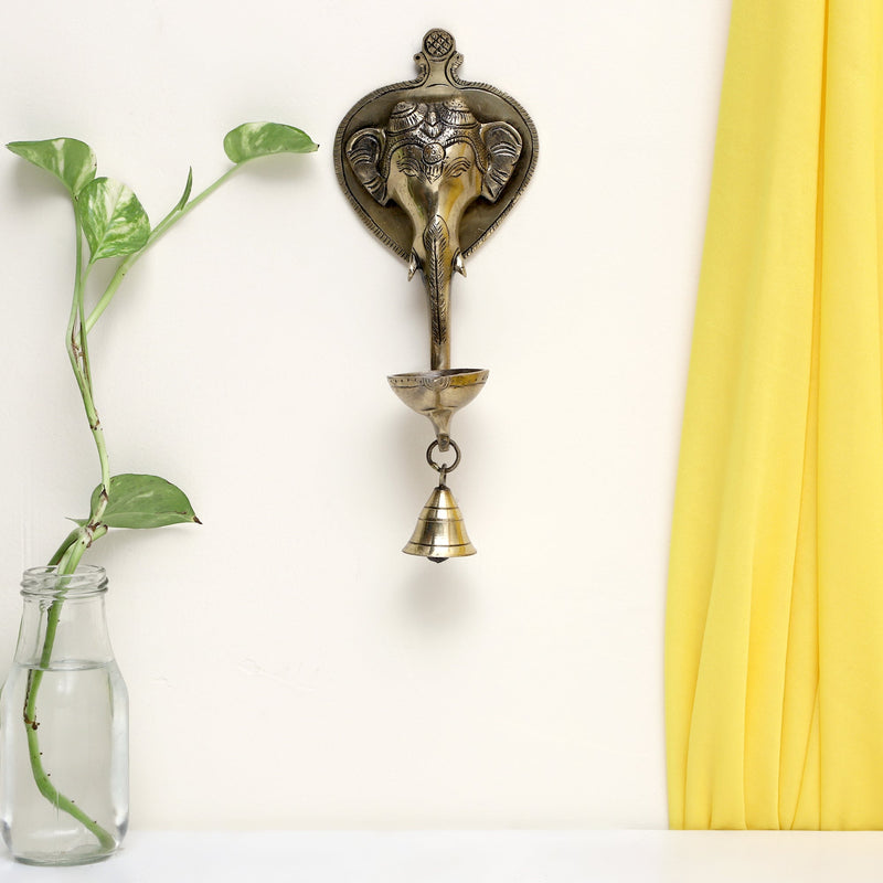 Brass Wall Diya - intricately designed brass oil lamp for wall mounting, golden finish, decorative home accent, traditional Indian Diya, emits a warm and inviting glow, ideal for enhancing wall decor and creating an ambiance of serenity, perfect for religious ceremonies and festive occasions, adds a touch of traditional charm to interior spaces.