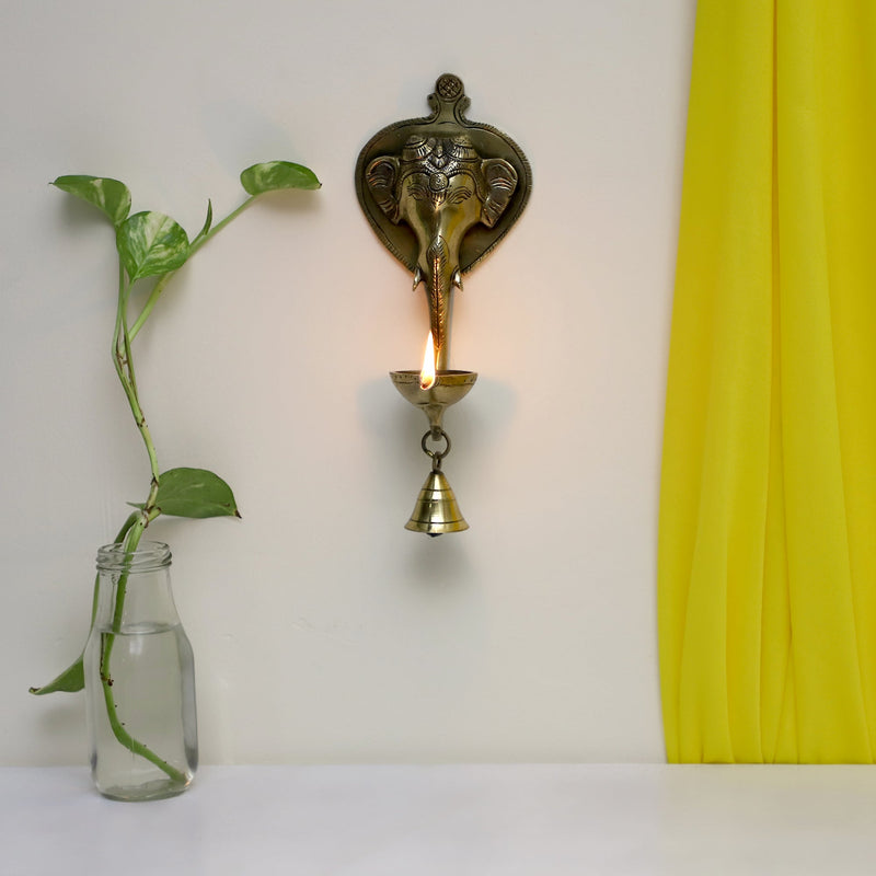 Brass Wall Diya - intricately designed brass oil lamp for wall mounting, golden finish, decorative home accent, traditional Indian Diya, emits a warm and inviting glow, ideal for enhancing wall decor and creating an ambiance of serenity, perfect for religious ceremonies and festive occasions, adds a touch of traditional charm to interior spaces.