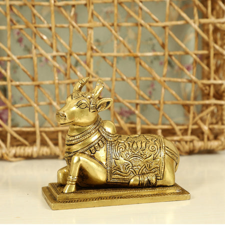 Brass God Nandi Cow - beautifully sculpted brass statue of Nandi, the sacred bull and vahana (vehicle) of Lord Shiva, golden finish, revered and divine deity, perfect for home decor and spiritual spaces, ideal for invoking blessings and divine guidance, symbolizes strength, devotion, and fertility, enhances the spiritual energy and fosters a sense of divine presence, a sacred and auspicious addition to your collection of brass sculptures and figurines.
